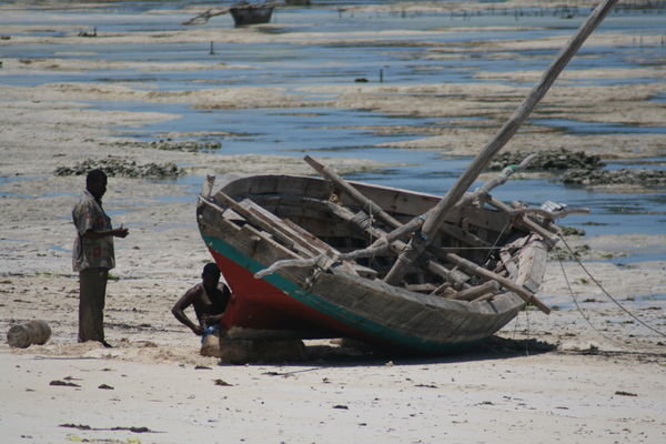 Zanz Locals Painting A Boat At Low Tide