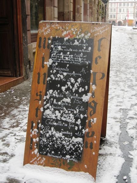 Restaurant sign covered in snow