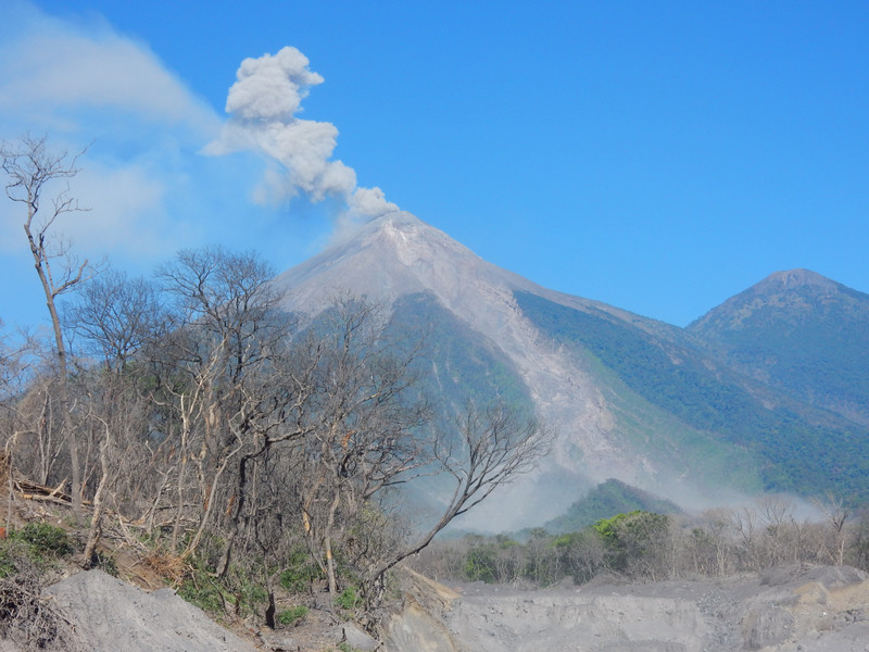 Rauchender Vulkan, im Vordergrund die zerstörte Natur vom letzten grossen Ausbruch