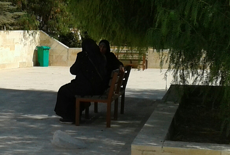 Robed women chat in the shade at Madaba