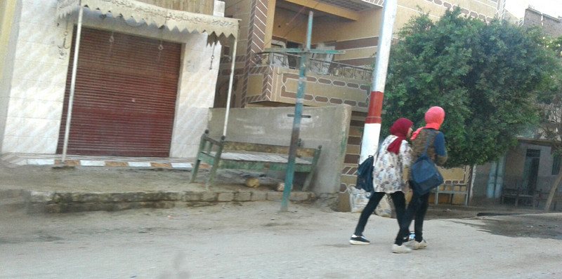 Random street scenes two young girls wear slacks and a hijab scarf 