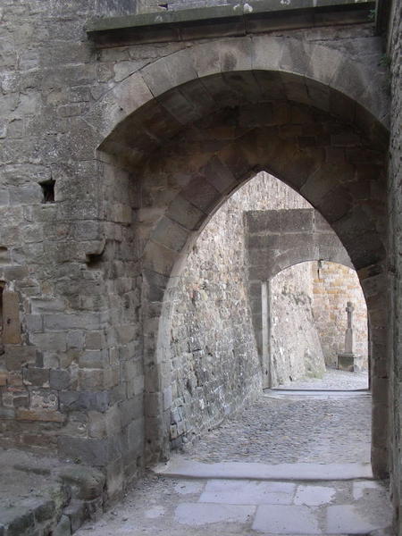 castle arches with a cross in the distance