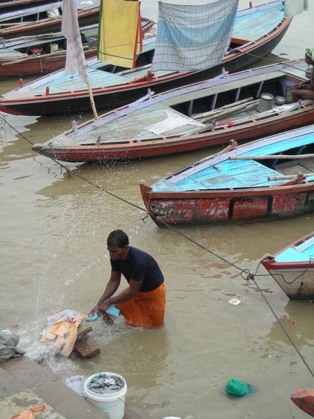 A dobi wallah washing clothes in the filthy Ganges