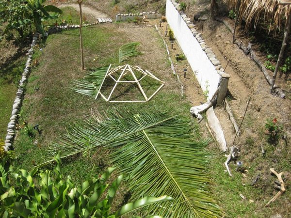 Putting together the wooden frame and the palm leaves to make the sun shade