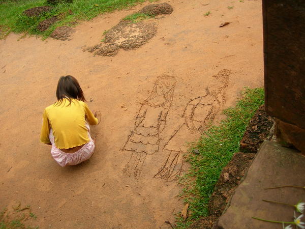 Cambodian girl drawing in the dirt