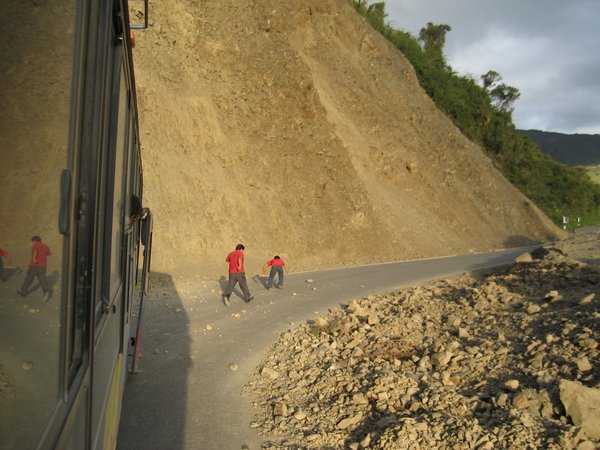 Driver and Assistant Clearing Rocks from the Road