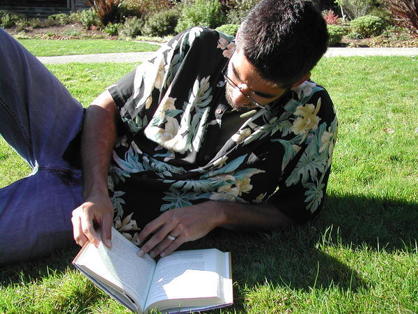 Darius reading on the lawn in the park