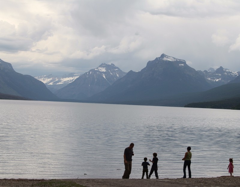 Family skipping stones on Lake McDonald