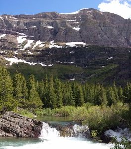 Mountains and waterfall on Swiftcurrent Lake