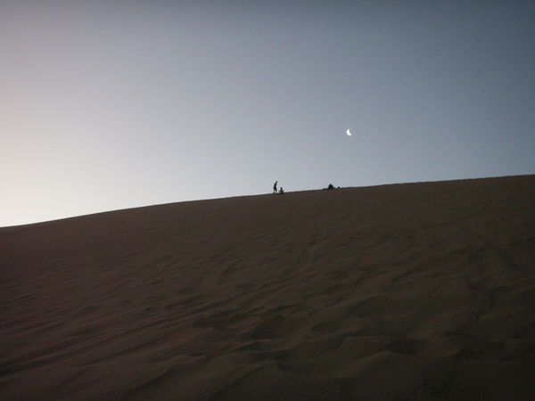 Tiny people on the tip of the sand dune
