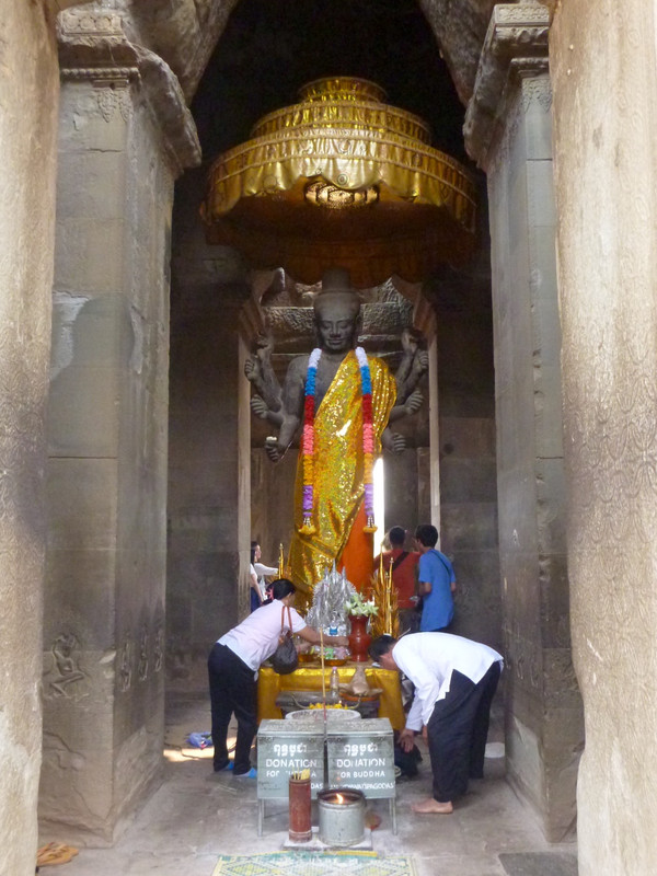 Faithful making offerings at the statue