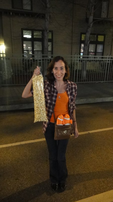 Denise's popcorn is almost as tall as she is