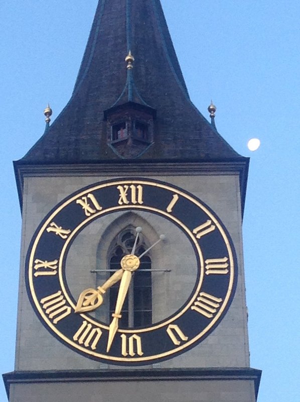 Morning moon peeking around clock tower