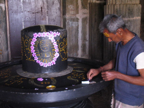 A local decorates a shrine in one of the many temples enclosed by the Kumbalgarh Fort