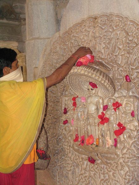 Jain priest sprinkles flowers over a shrine in the beautifully ornate Ranakpur Temple