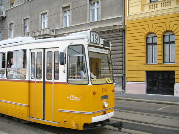 Mustard yellow tram and building