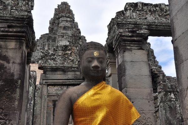 Many buddha statues are covered with saffron robes