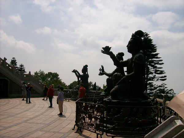 Three of the eight smaller statues surrounding the buddha
