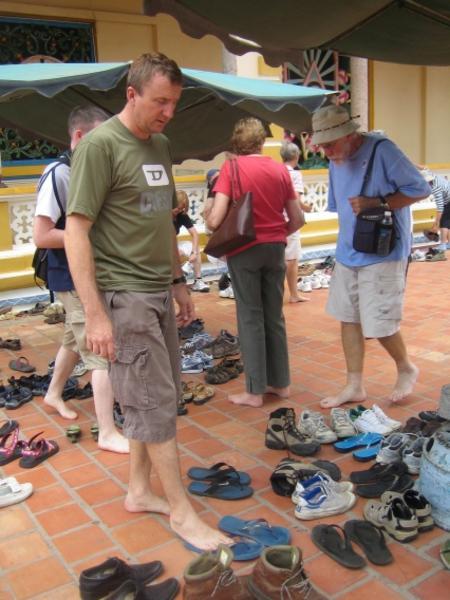 Dave taking off his thongs to enter the Cao Dai temple