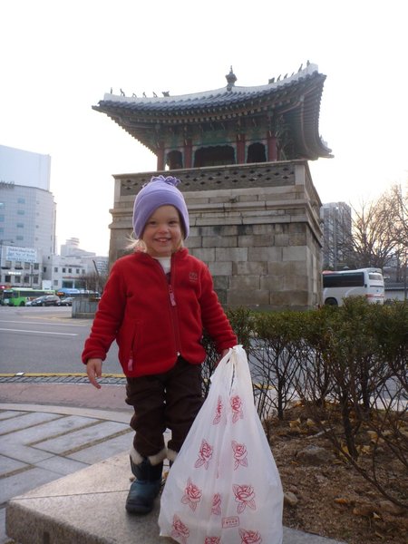 Samara getting take out noodles in front of an old palace gate now being used as a traffic island
