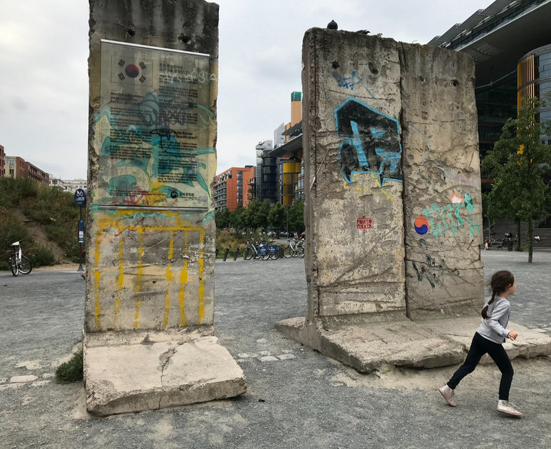 Maya runs by the Berlin Wall