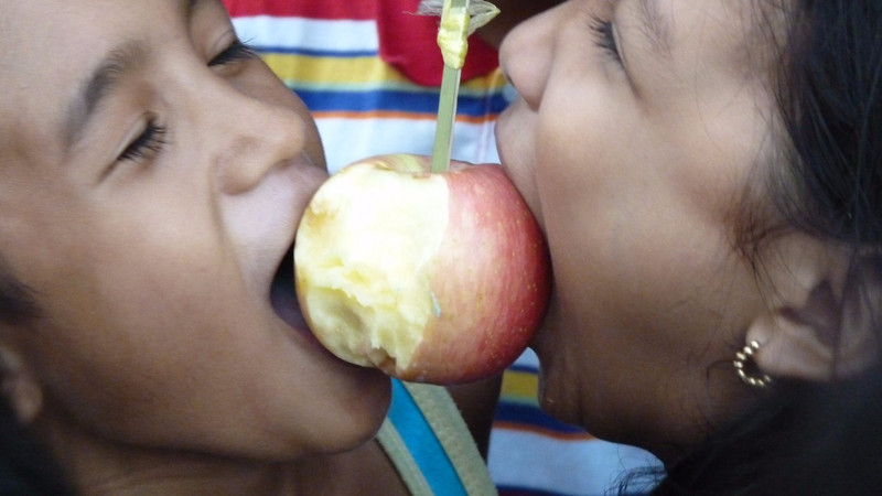 Fiesta - jeu qui consiste à manger le plus vite possible une pomme à deux, sans les mains