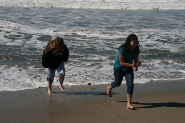 Girls running from the waves