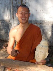 A monk poses proudly with his masterpiece