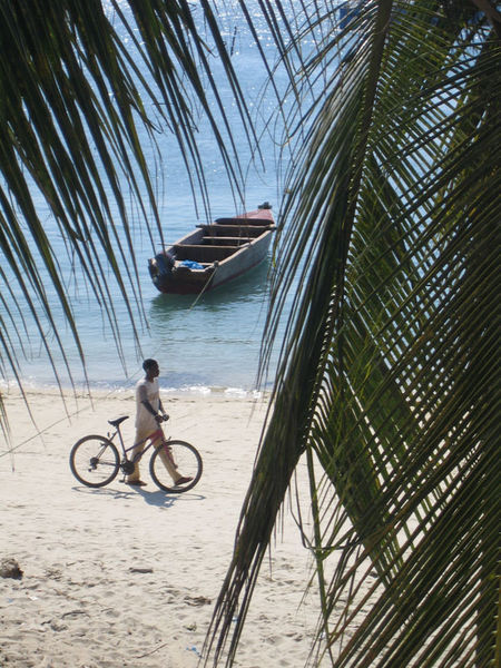 Boat, man and bike on the beach at Stone Town