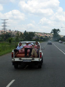 Kids sitting on bags of popcorn in the back of a ute