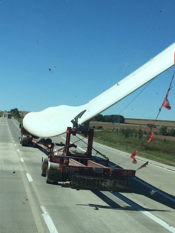 A huge windmill propeller moving down the highway.