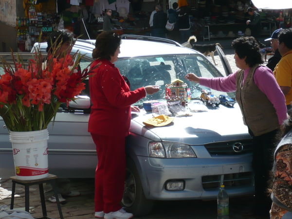 A car being prepared to be blessed by a priest
