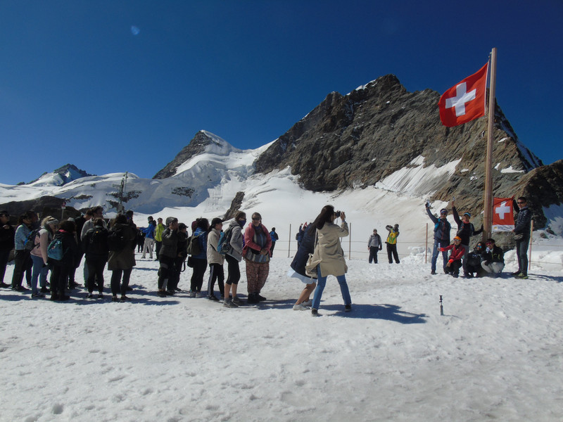 A queue to have a photo holding the Jungfraujoch flag