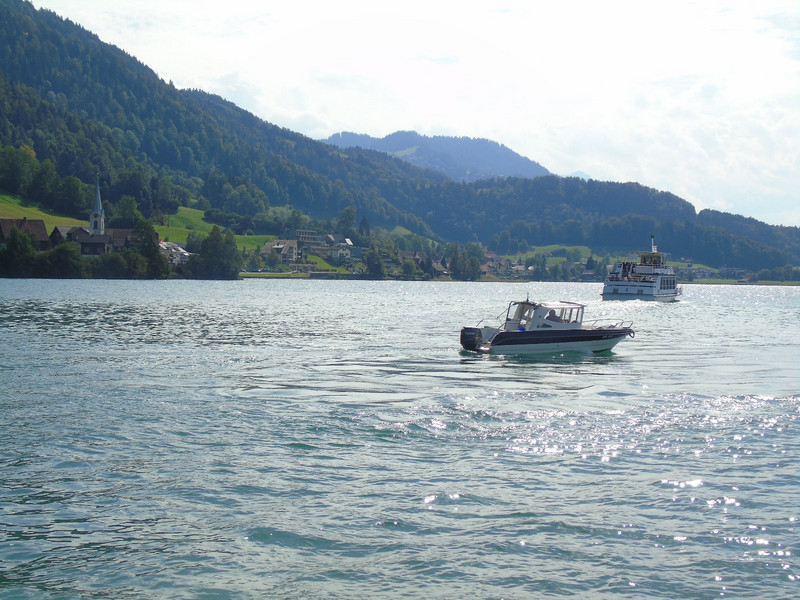 A small ferry moves between several stops on the perimeter of the lake