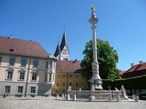 A column supporting a gold statue of the Virgin Mary with Eichstatt Cathedral in the background