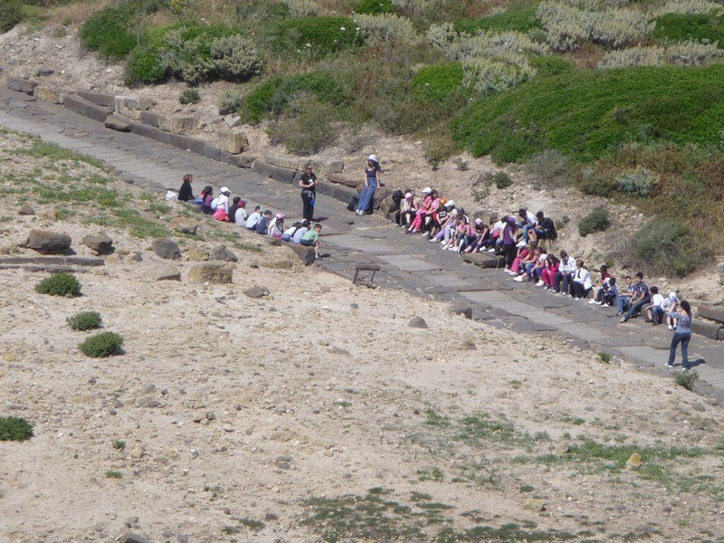 Children sitting on a Roman road having a history lesson