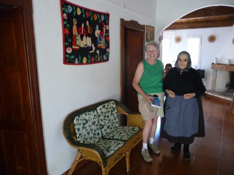 A lady shows Wendy her woollen embroidery in one lodging