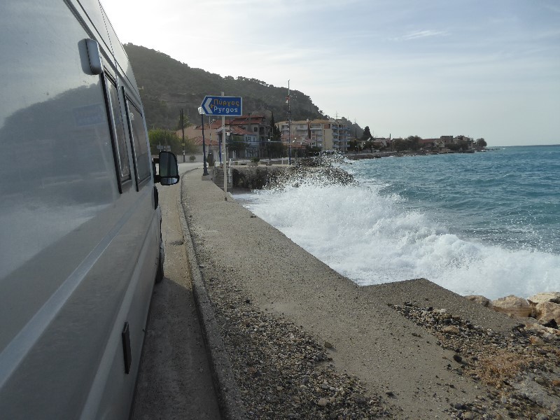The coastal road with the sea breaking over the walls