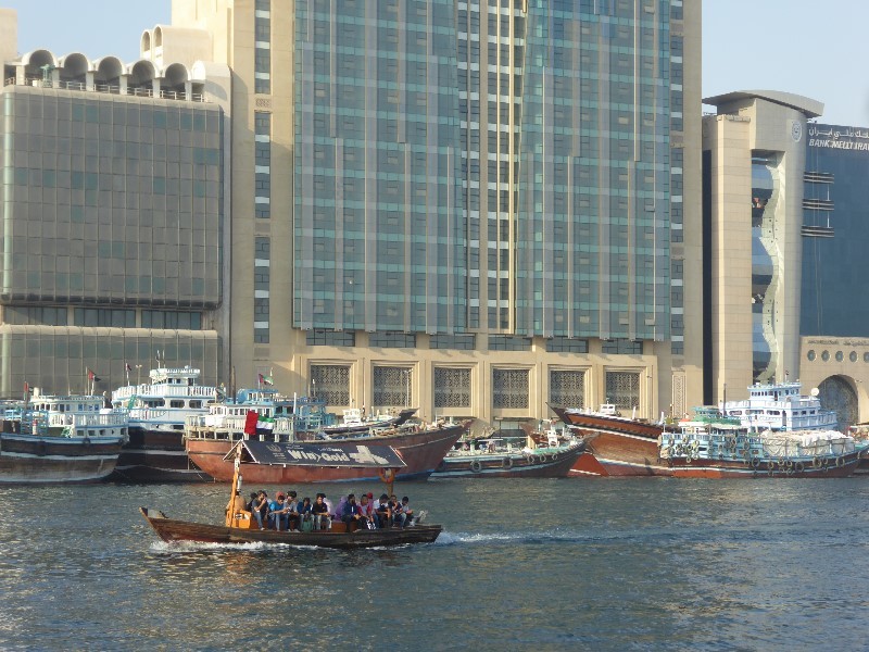 Two traditional types of boats on the Creek. The abra ferry in the foreground and cargo bearing dhows in the background