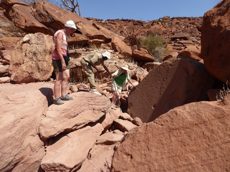 The guide helping Wendy along the rocky path to the Twyfelfontein site