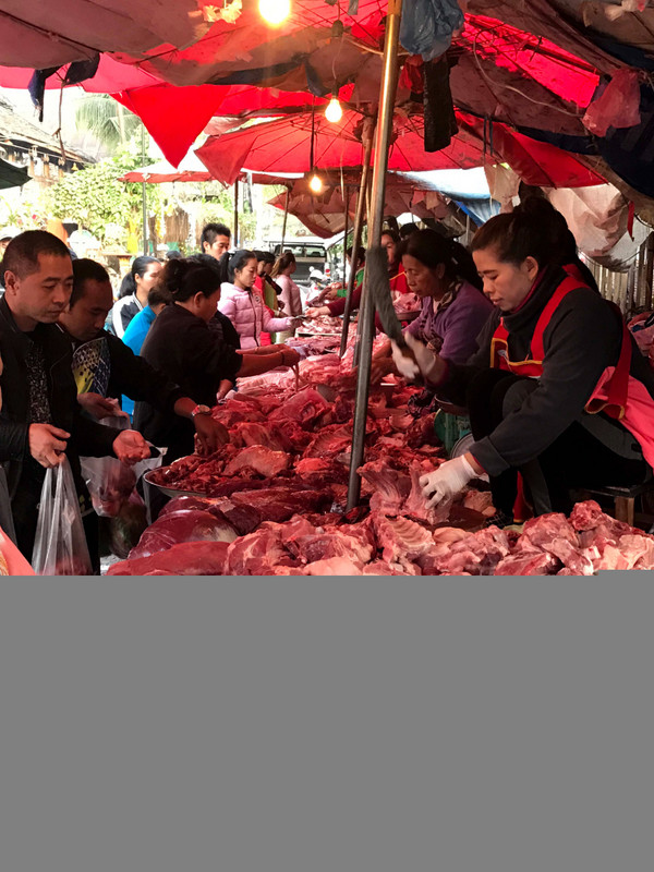 Woman cutting meat at the market