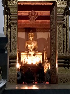 Buddha lit by candle light in temple