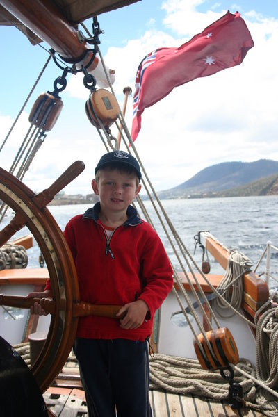 Samuel at  the wheel of the tall ship
