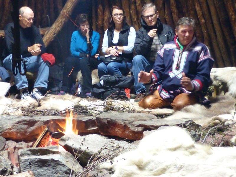 Learning more about the Sami culture and history while seated on reindeer skins that are placed upon birch twigs, directly on the ground around the open fire.