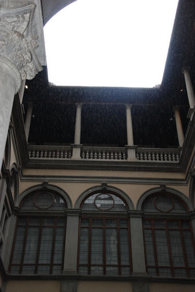 a really old building with a cool shot of rain coming down.