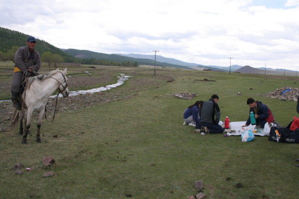 Preparing picnic spread besides a stream