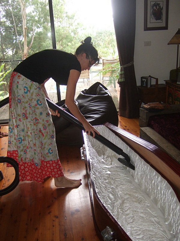 Helen vacuums the coffin