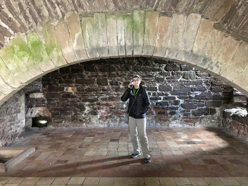 Dot standing in the giant cooking fireplace in the kitchen of the Castle