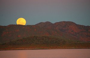The moon rising above island in Lake Argyle