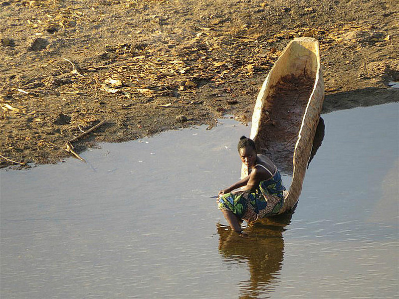 Woman in dug out canoe from sausage tree